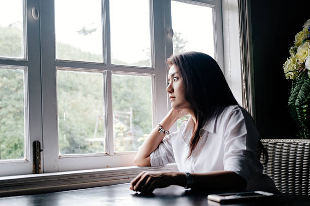 istock Girl Is Sitting And Looking For Something Outside The Window 600401944