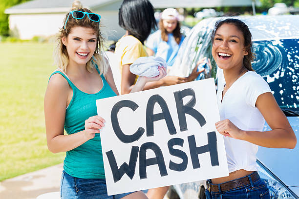 istock Fun friends promote car wash fundraiser 600403284