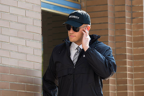 istock Young Security Guard Standing In Front Of The Entrance 600404134
