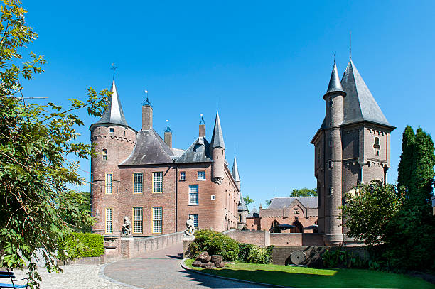 Heeswijk, The Netherlands - August 25, 2016: Entry to the mailn building of Heeswijk castle. The castle has been built on the location of a former moated castle near Heeswijk in the Dutch province of North Brabant. The castle dates back to a motte from the 11th century. During the subsequent centuries the motte was replaced and extended to the castle in its current size.  The castle, which has played a crucial role in the history of the Netherlands, has undergone a complete restoration in 2005. 
