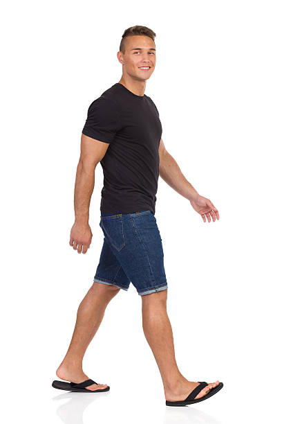 istock Man Walking In Flip-Flops And Looking At Camera 600405254