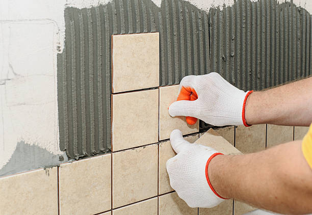 istock Worker  putting  tiles on the wall in the kitchen. 600406036