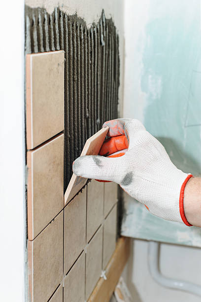 istock Worker  putting  tiles on the wall in the kitchen. 600406842
