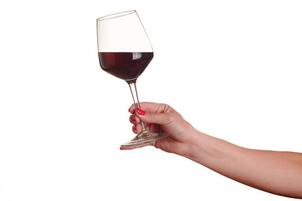 mano femenina con copa de vino tinto - copa de vino fotografías e imágenes de stock