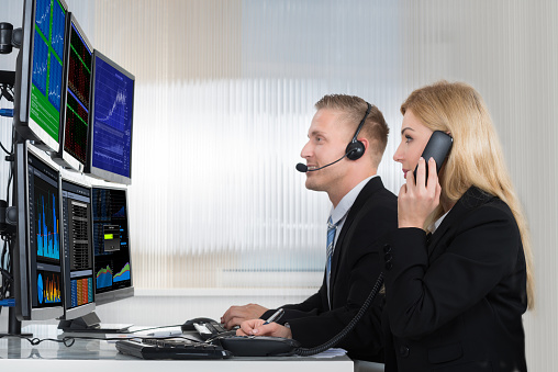 smiling female helpline operator with headphones and laptop