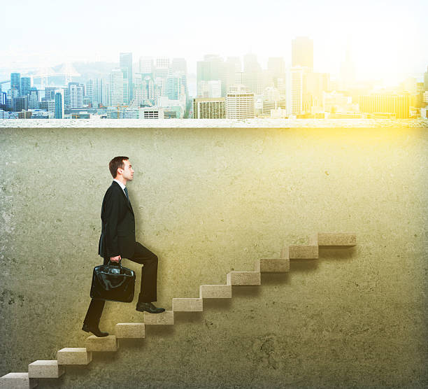 istock businessman climbing concrete ladder 600408212