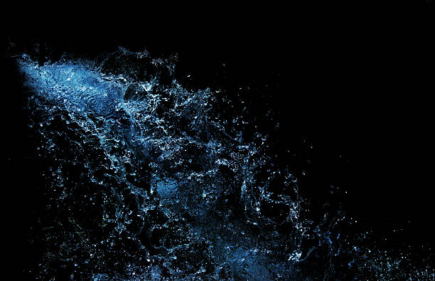 blue water splash isolated on black background stock photo