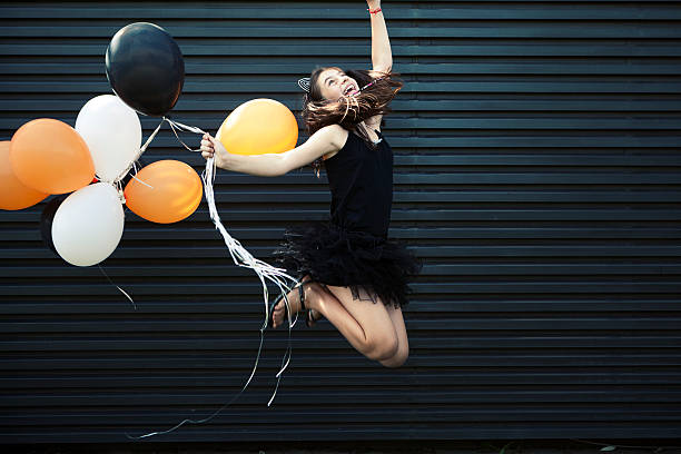 istock Girl dressed for Halloween jumping with balloon 600411790