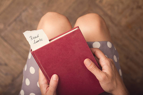 istock Woman holding a red book with a paper message 600412084