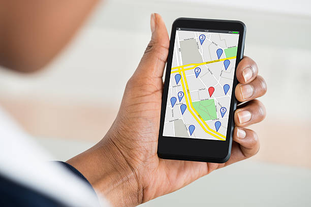 istock Woman's Hand Holding Mobile Phone With Location Mark On Map 600412158