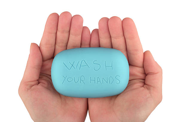 Hands holding blue soap bar with wash your hands written