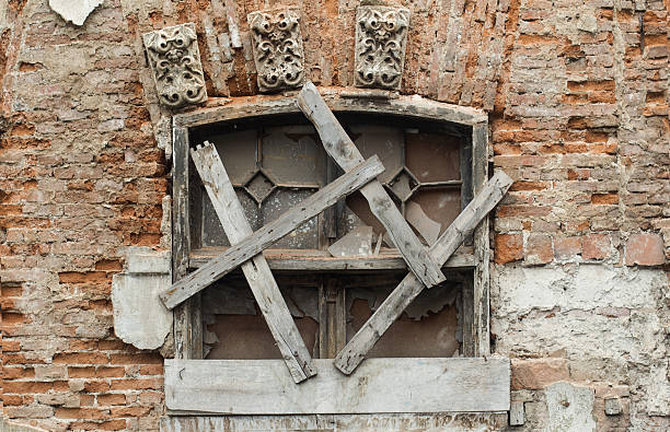 istock Damaged window covered with wood 600412622