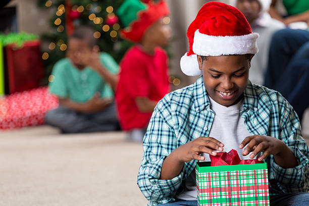istock Smiling preteen boy opening a Christmas gift box 600413526