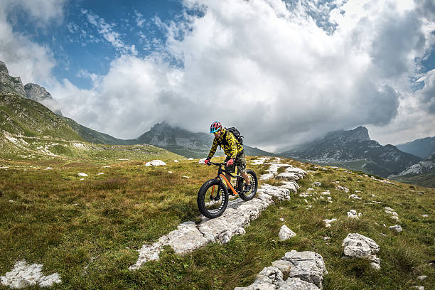 Male bicycle rider in the mountains Male cyclist riding his fat bike in off-road areas and beautiful panoramic nature in the mountains. durmitor national park photos stock pictures, royalty-free photos & images