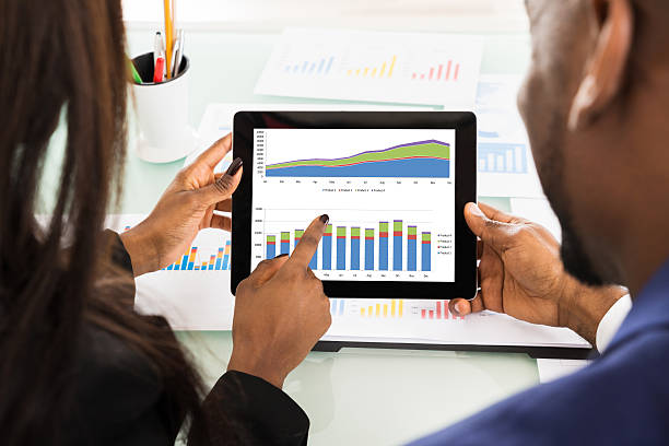 istock Two Businesspeople Discussing Graph On Digital Tablet 600413914