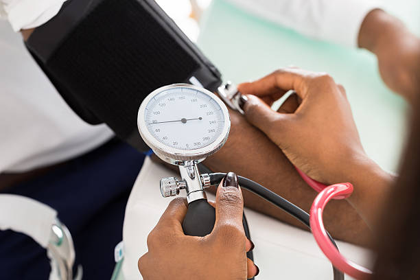 Doctor Measuring Patients Blood Pressure Close-up Of Doctor Measuring Patients Blood Pressure With Stethoscope hypertensive photos stock pictures, royalty-free photos & images