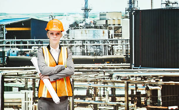 istock Female architect standing at the oil refinery 600414164