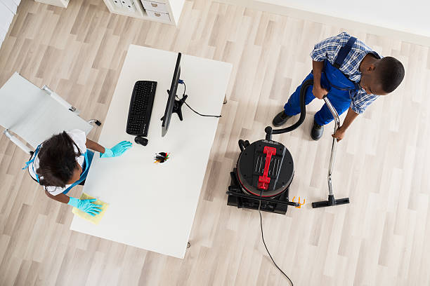 istock Young Male And Female Janitor Cleaning Office 600414614