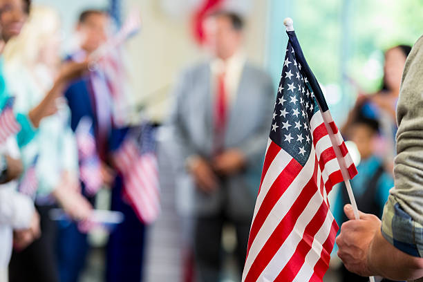 Supporters waving American flags at political campaign rally Focus on American flag in a diverse crowd of people. Supporters are cheering for a local candidate at a campaign rally or political town hall meeting. democratic party usa photos stock pictures, royalty-free photos & images