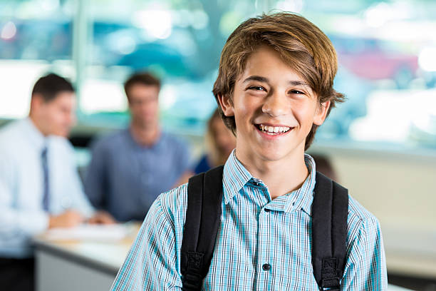 un jeune élève adolescent souriant pendant la conférence des parents et des enseignants - parent teenager caucasian teenage boys photos et images de collection