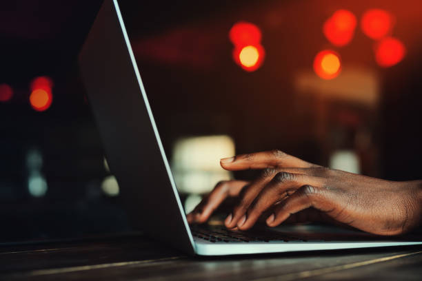 istock Black man's hands typing on keyboard. Person working with 600415488