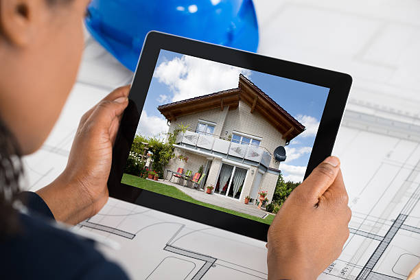 istock Woman Holding Digital Tablet Over Blueprint 600416078