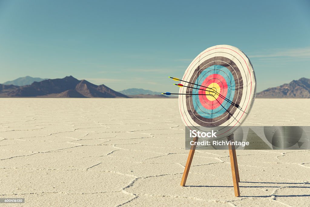 Bow and Arrow Target with Arrows A target with several arrows in the bullseye stands on the Bonneville Salt Flats. The business has found success and it mark for the future.  Sports Target Stock Photo