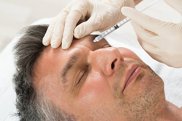 man receiving cosmetic injection with syringe - lifting device imagens e fotografias de stock