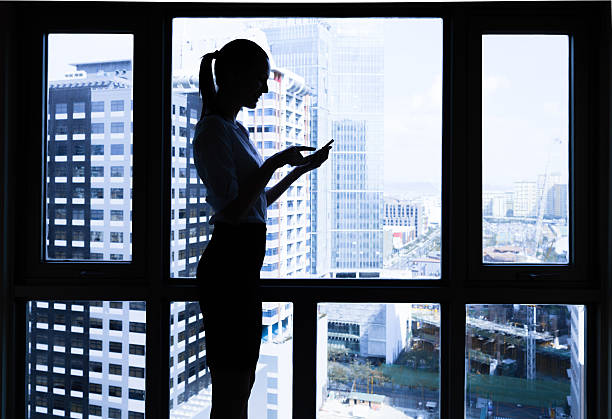 istock Woman using mobile phone in the office 600417418