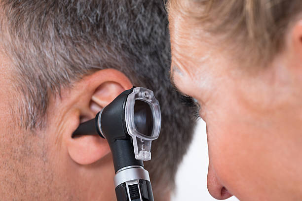 médico examinar paciente de oreja - otoscopio fotografías e imágenes de stock