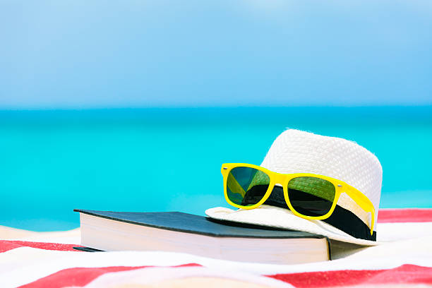 istock Book, sunglasses and hat on the beach. 600418116