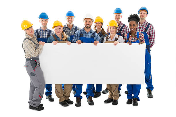 happy construction workers holding blank billboard - manual worker full length isolated on white standing imagens e fotografias de stock