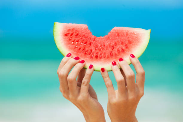 Hand holding watermelon on the beach Hand holding watermelon on the beach. quench your thirst pictures stock pictures, royalty-free photos & images