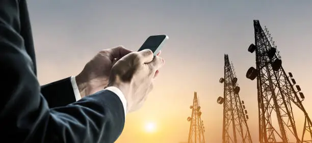 Photo of Businessman using mobile phone with multi exposure Telecommunication towers