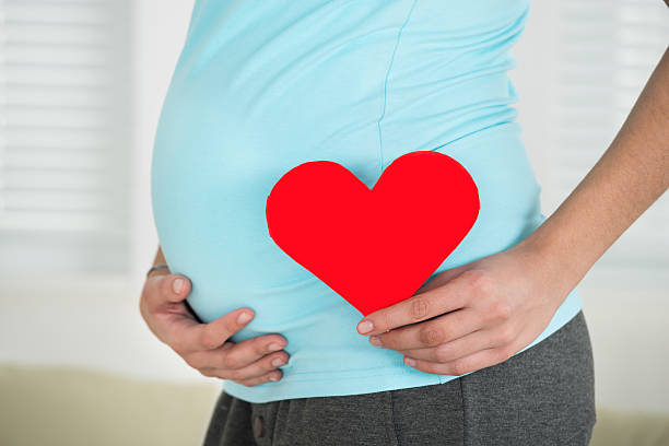 istock Pregnant Woman Holding Heart Shape 600671976