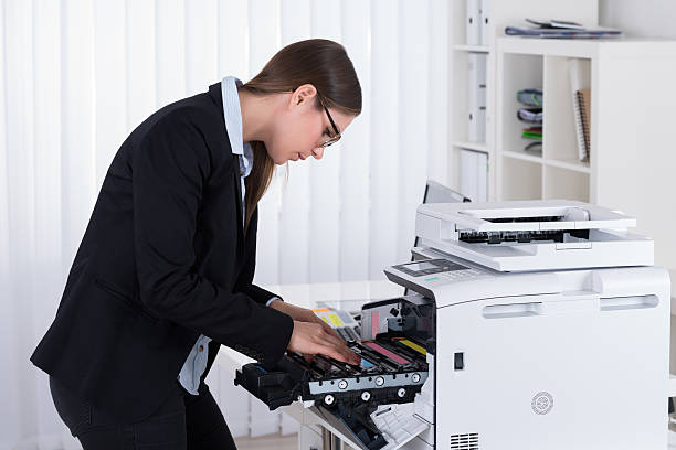 istock Businesswoman Fixing Copy Machine 600672742