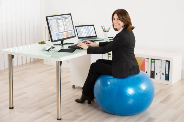 femme d’affaires assise sur le travail de balle pilates - photos de fauteuil sphérique photos et images de collection