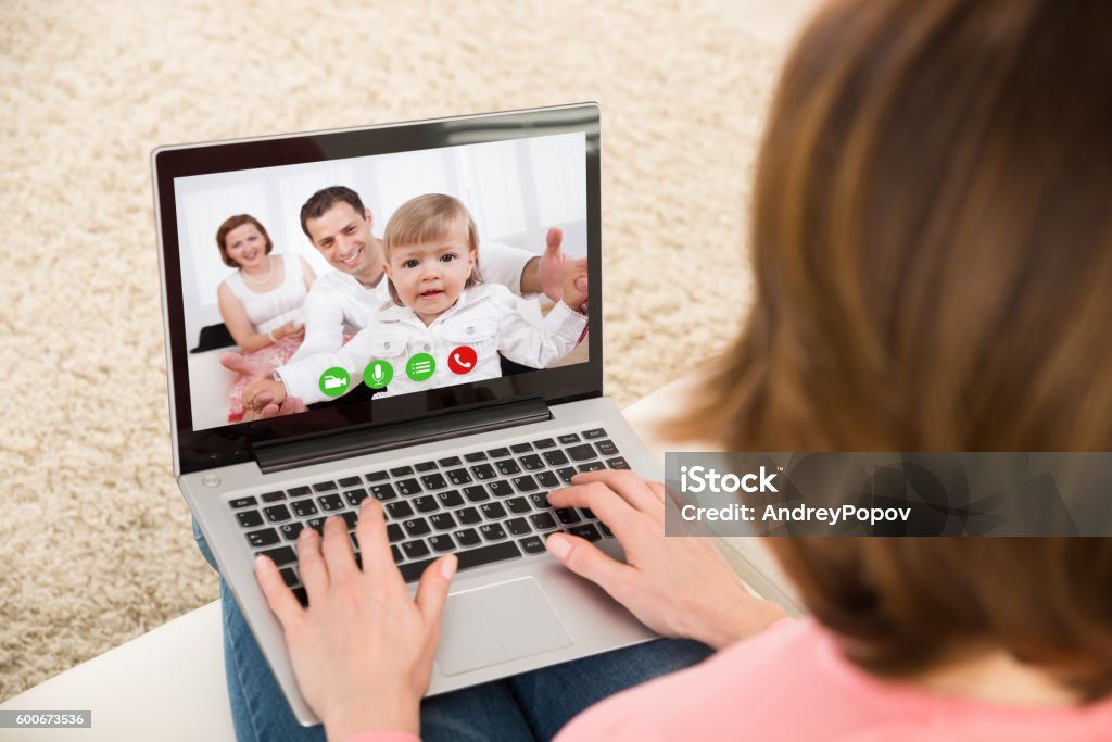 Frau Videochatting mit Familie auf Laptop - Lizenzfrei Familie zuhause Stock-Foto
