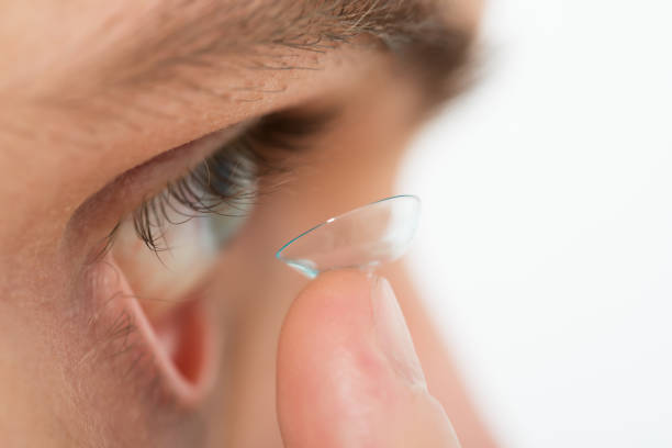 istock Man Putting Contact Lens In Eye 600674406