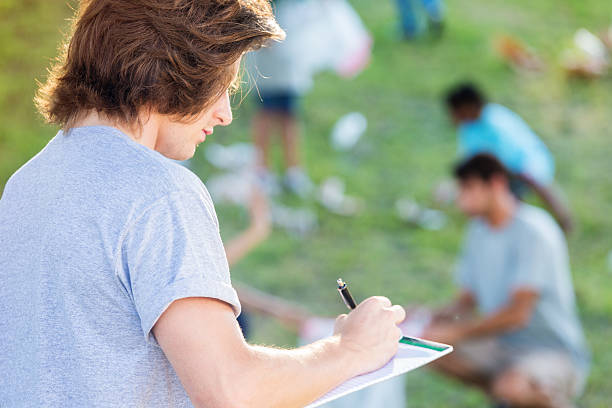 istock Community outreach volunteer writing down information at park 600674420
