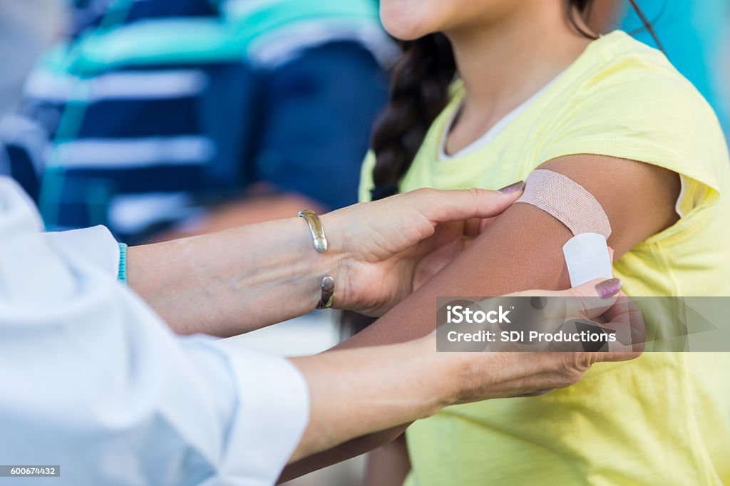 Médecin appliquant un pansement au patient au salon de la santé en plein air - Photo de Enfant libre de droits