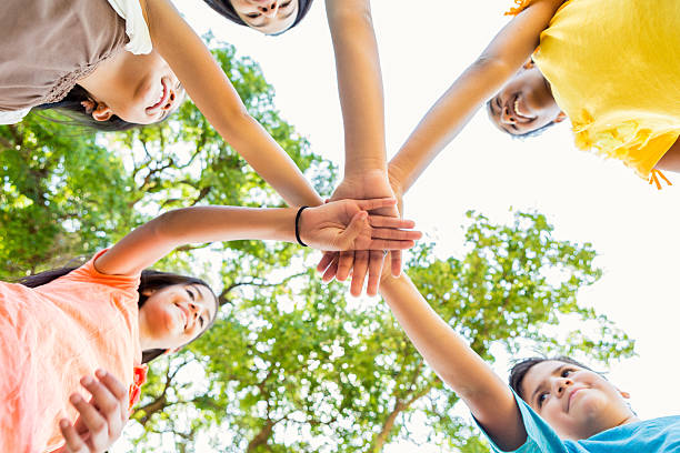 istock Multi ethnic group of kids in a huddle outdoors 600674438