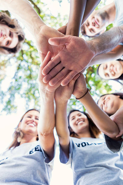 istock Diverse group of adults outdoors in a huddle 600674450