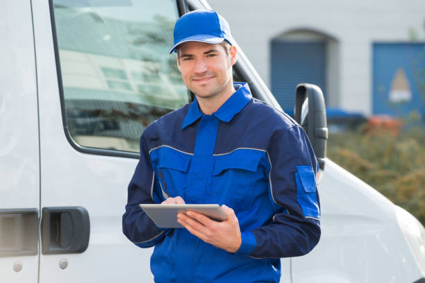 istock Delivery Man Smiling Using Digital Tablet By Truck 600674918