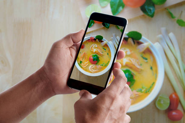 istock smart phone take a shot of Tom Yum soup 600676340
