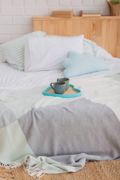 istock Two mugs on a tray white bed, breakfast concept 600678198