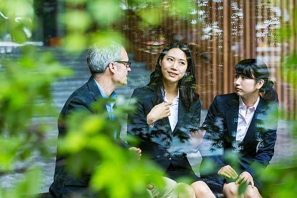 english businessman working advising japanese corporate professional business women - respect japan business togetherness imagens e fotografias de stock