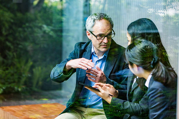 empresario inglés que trabaja asesorando a mujeres de negocios profesionales corporativas japonesas - help palabra en inglés fotografías e imágenes de stock