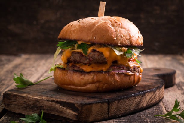 istock Tasty grilled burger with lettuce and mayonnaise , rustic wooden table 600683512