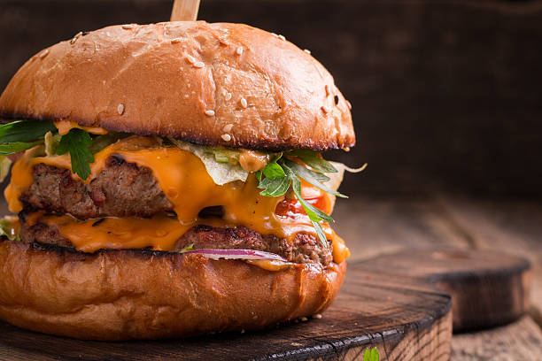 istock Tasty grilled burger with lettuce and mayonnaise , rustic wooden table 600683628